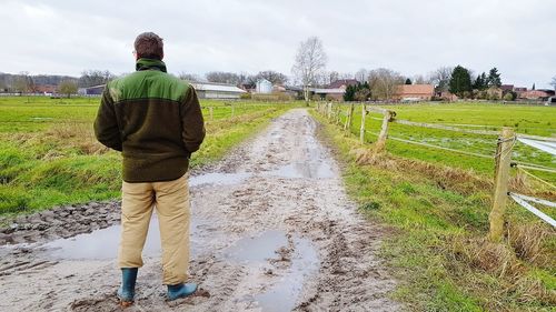 Rear view of man standing in farm