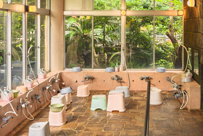 Japanese indoor onsen hot spring with furo-isu bath chairs, shower faucets and karan buckets.