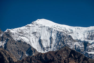 Scenic view of snowcapped mountains against clear blue sky