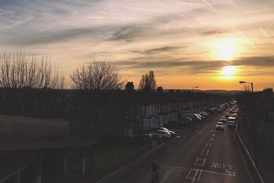 Cars on road against sky during sunset