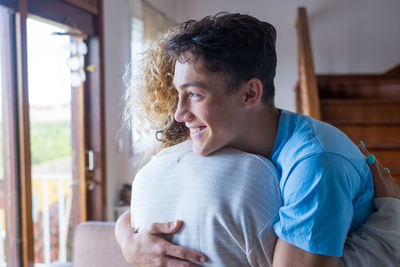 Portrait of smiling young man sitting at home