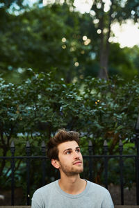 Portrait of young man against tree
