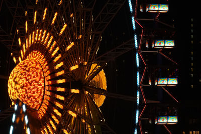 Low angle view of illuminated ferris wheel at night