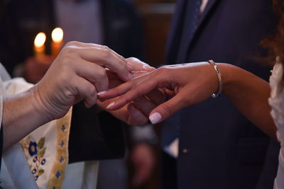 Cropped image of bridegroom inserting wedding ring in bride finger