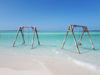 Lifeguard hut on beach against clear blue sky