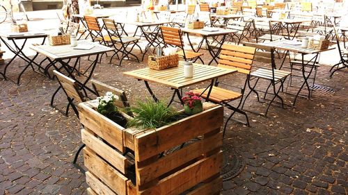 High angle view of empty chairs and tables at sidewalk cafe