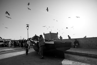 People flying birds against clear sky