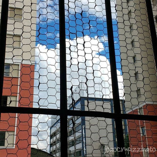 architecture, built structure, building exterior, window, full frame, glass - material, backgrounds, city, pattern, building, wall - building feature, metal grate, day, brick wall, outdoors, no people, protection, fence, safety, reflection