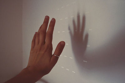 Close-up of hand gesturing against wall