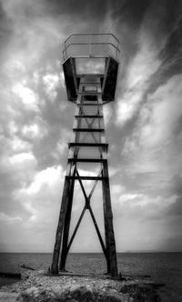 Low angle view of tower on beach against sky