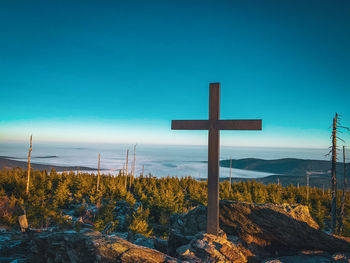 Scenic view of cross against clear blue sky