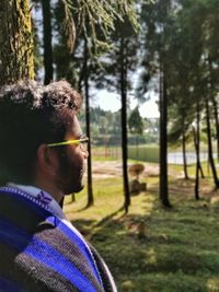 Young man against trees in forest