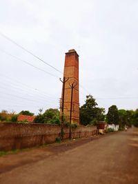 Old factory by building against sky