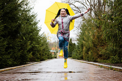 Full length of young man jumping in forest