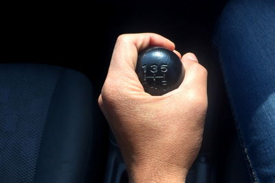 Close-up of hand holding gearshift in car