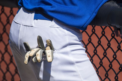 Midsection of referee with gloves in pocket standing at court