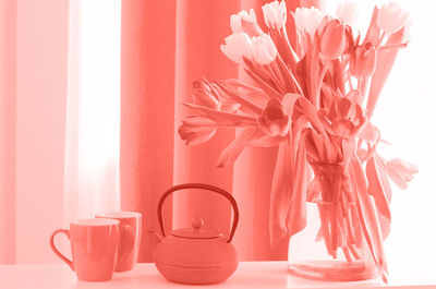 Close-up of pink roses in vase on table at home