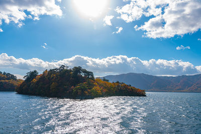 Scenic view of sea by mountains against sky