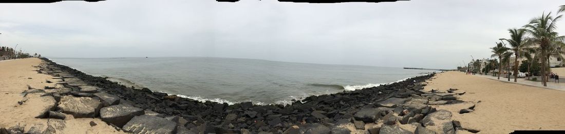 Panoramic view of calm beach against sky