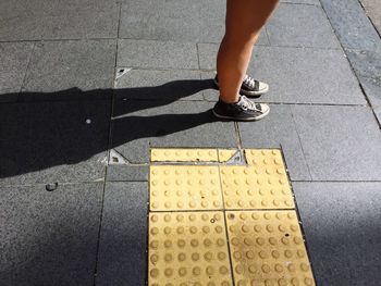 Low section of woman standing on tiled floor