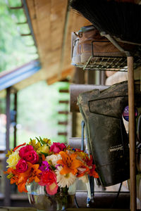 Colorful flowers in vase by shoes rack