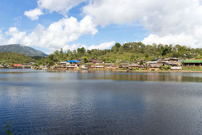 Scenic view of lake by buildings against sky