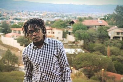 Portrait of man standing against buildings in city