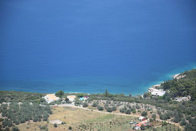 High angle view of buildings by sea against blue sky