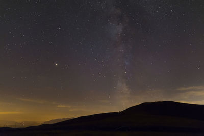 Scenic view of silhouette mountain against sky at night