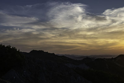 Scenic view of silhouette mountains against sky at sunset