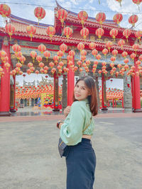 Rear view of young woman standing on street