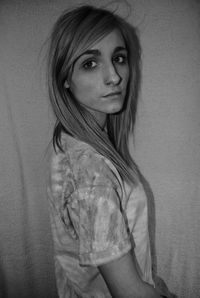 Portrait of woman standing against wall