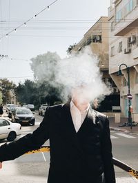 Man standing on street against sky in city