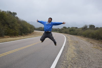 Full length of man jumping on road