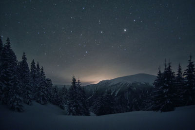 Scenic view of snowcapped mountains against sky at night