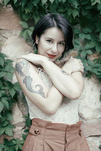 Portrait of smiling beautiful young woman standing outdoors