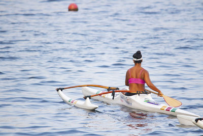 Rear view of man surfing in sea