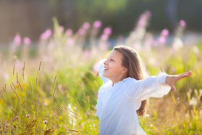 Side view of young woman standing on field