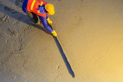 High angle view of man working against yellow wall