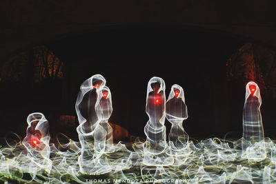 Close-up of illuminated lighting equipment on table against black background