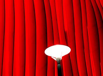 Close-up of light against red curtain