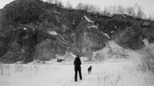 Rear view of women walking on snow covered landscape