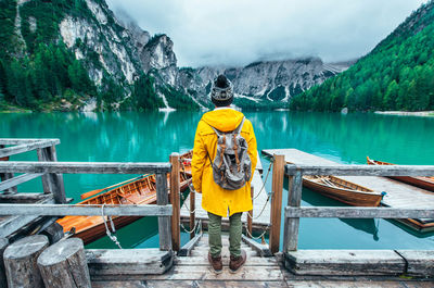 Rear view of man standing by lake