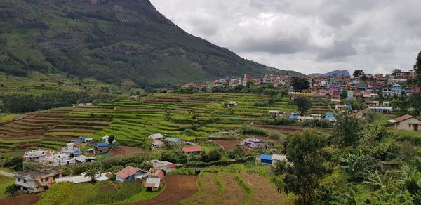Scenic view of village and houses against sky