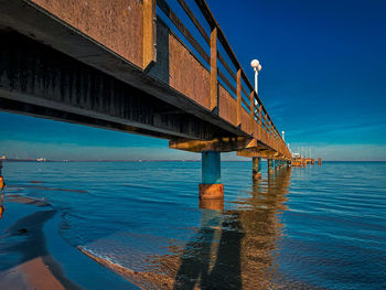 Pier over sea against blue sky