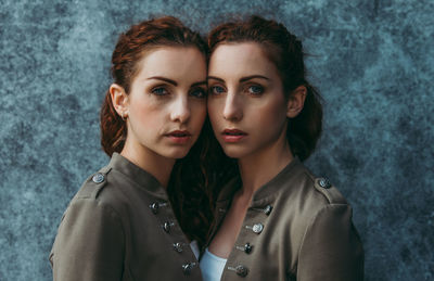 Portrait of siblings against wall