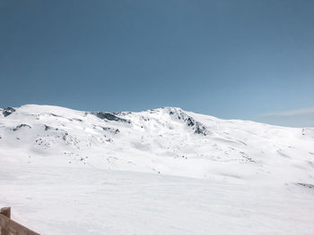 Scenic view of snowcapped mountains against clear blue sky