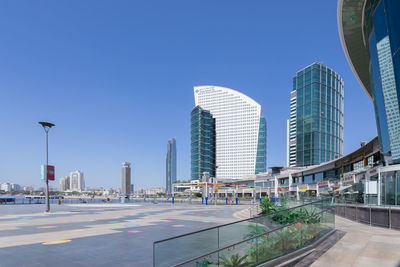 Modern buildings in city against clear blue sky