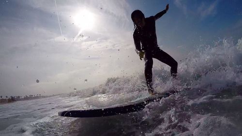 Low angle view of man jumping on beach against sky