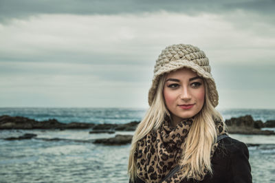 Portrait of a smiling young woman in sea against sky